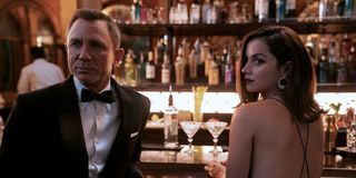 James Bond (Daniel Craig) and Paloma (Ana de Armas) sit at a bar in 'No Time To Die'