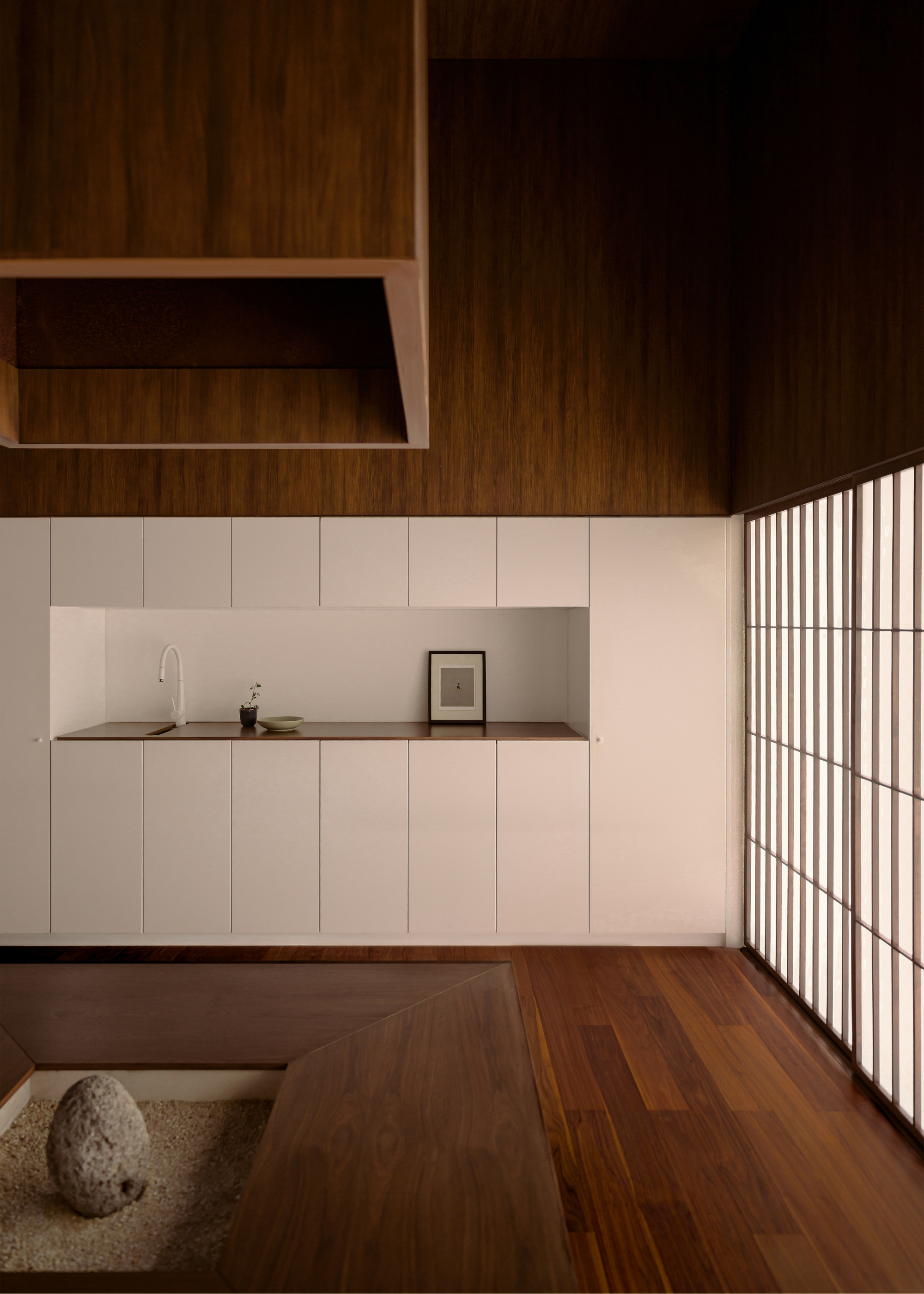 A bright Japanese-inspired space with a stone feature, sliding doors, and a small sink area