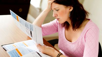 A stressed customer examining her energy bills