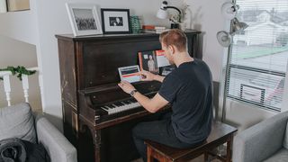 Man cues up a piano lesson on his tablet
