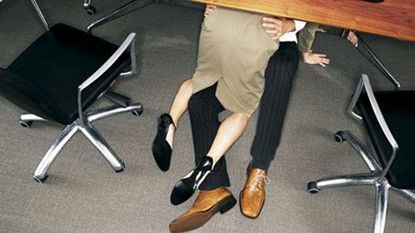 Couple in embrace under a desk