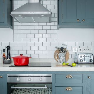 kitchen room with white wall tiles and cooker with chimney
