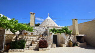 Two characterful limestone trulli in the Itria Valley