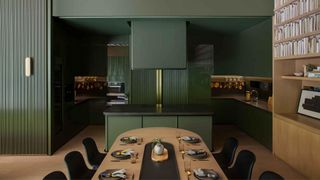 A color drenched kitchen with a dining table set up for dinner