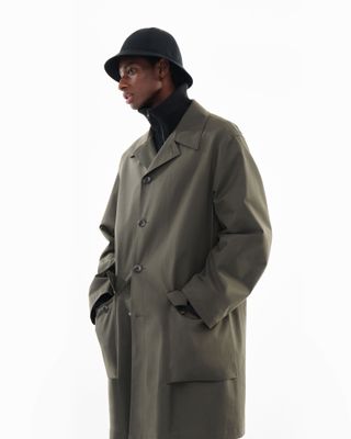 Man looking to the side in hat and coat by Uniqlo U