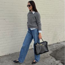 Liv Perez wearing a grey sweater layered over a collared shirt.