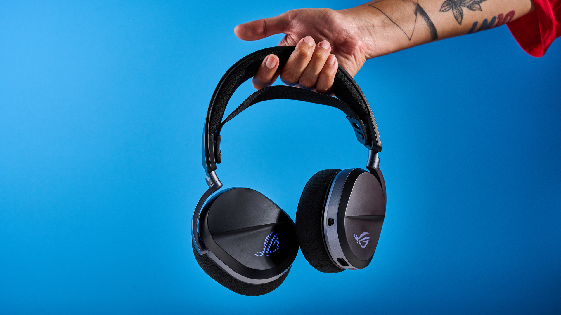 A black Asus ROG Pelta gaming headset with a detachable mic and RGB lighting