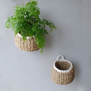 Brown and cream woven plant holders on a grey wall