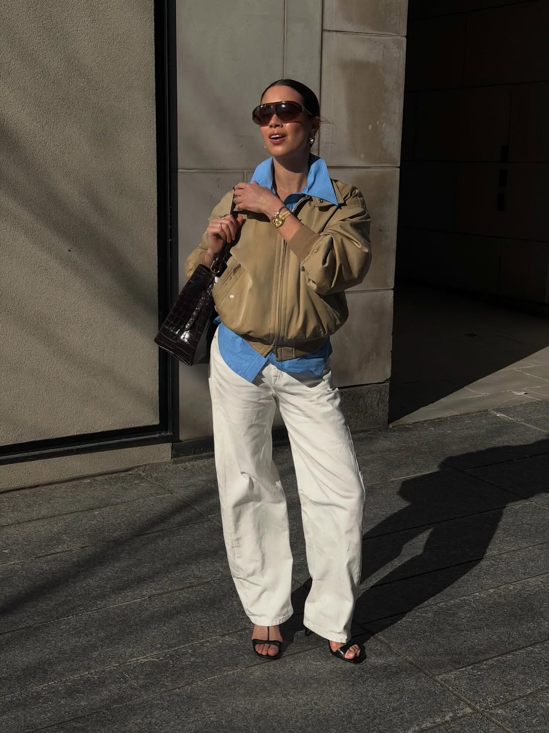 Influencer Sasha Mei wearing heeled sandals and cream barrel leg jeans.