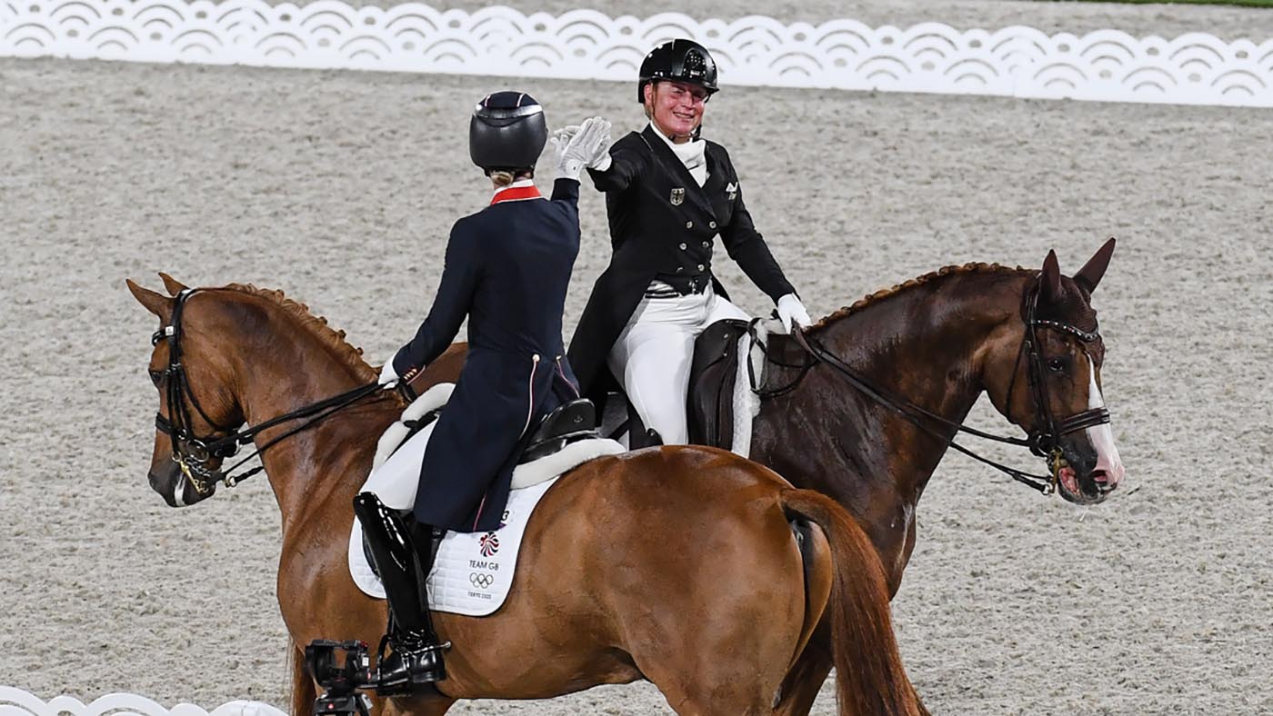 Charlotte Dujardin and Isabell Werth share a high-five in the Tokyo Olympics
