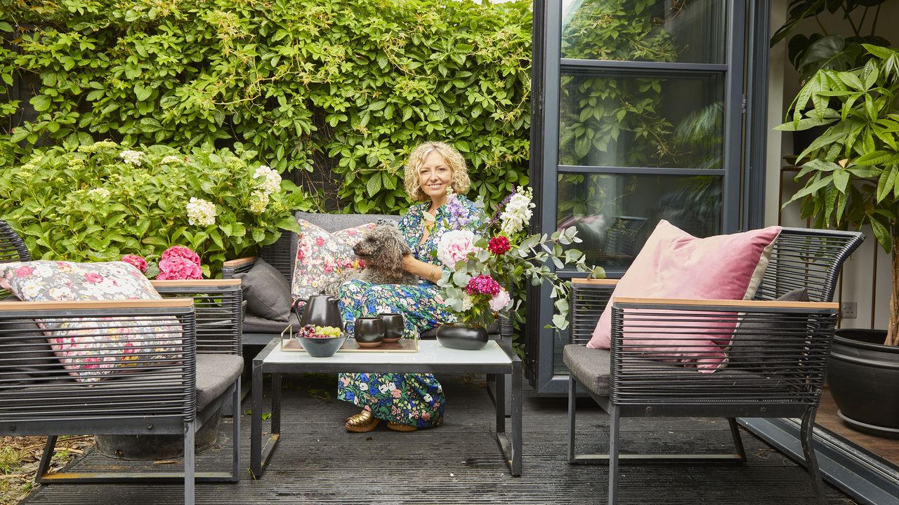 Woman sitting on a decked seating area with a dog