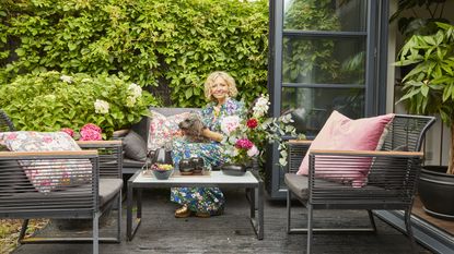 Woman sitting on a decked seating area with a dog