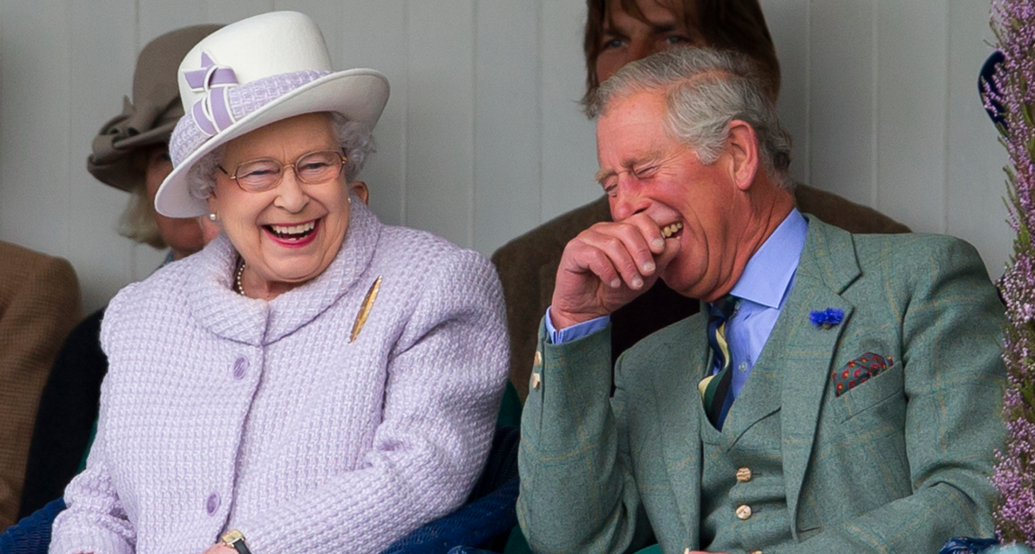 Queen Elizabeth and King Charles sitting next to each other and laughing hysterically