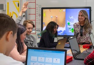 Small group in classroom using NUITEQ Snowflake on laptop computers