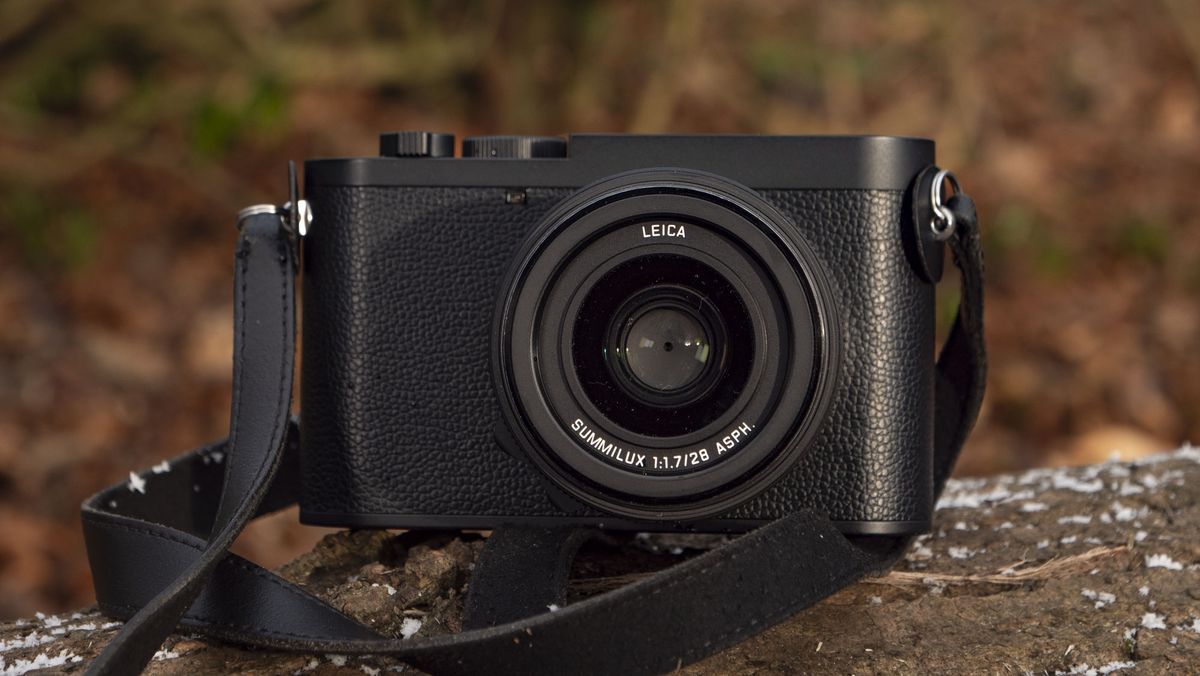 Leica Q3 Monochrom compact camera outside on a snow-dusted log