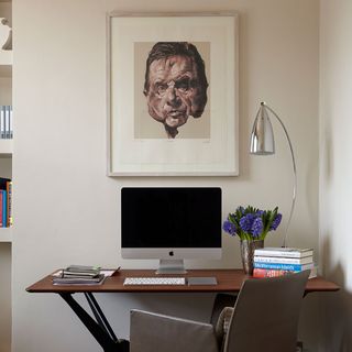 office home with desk and computer on desk with table lamp and fame on wall