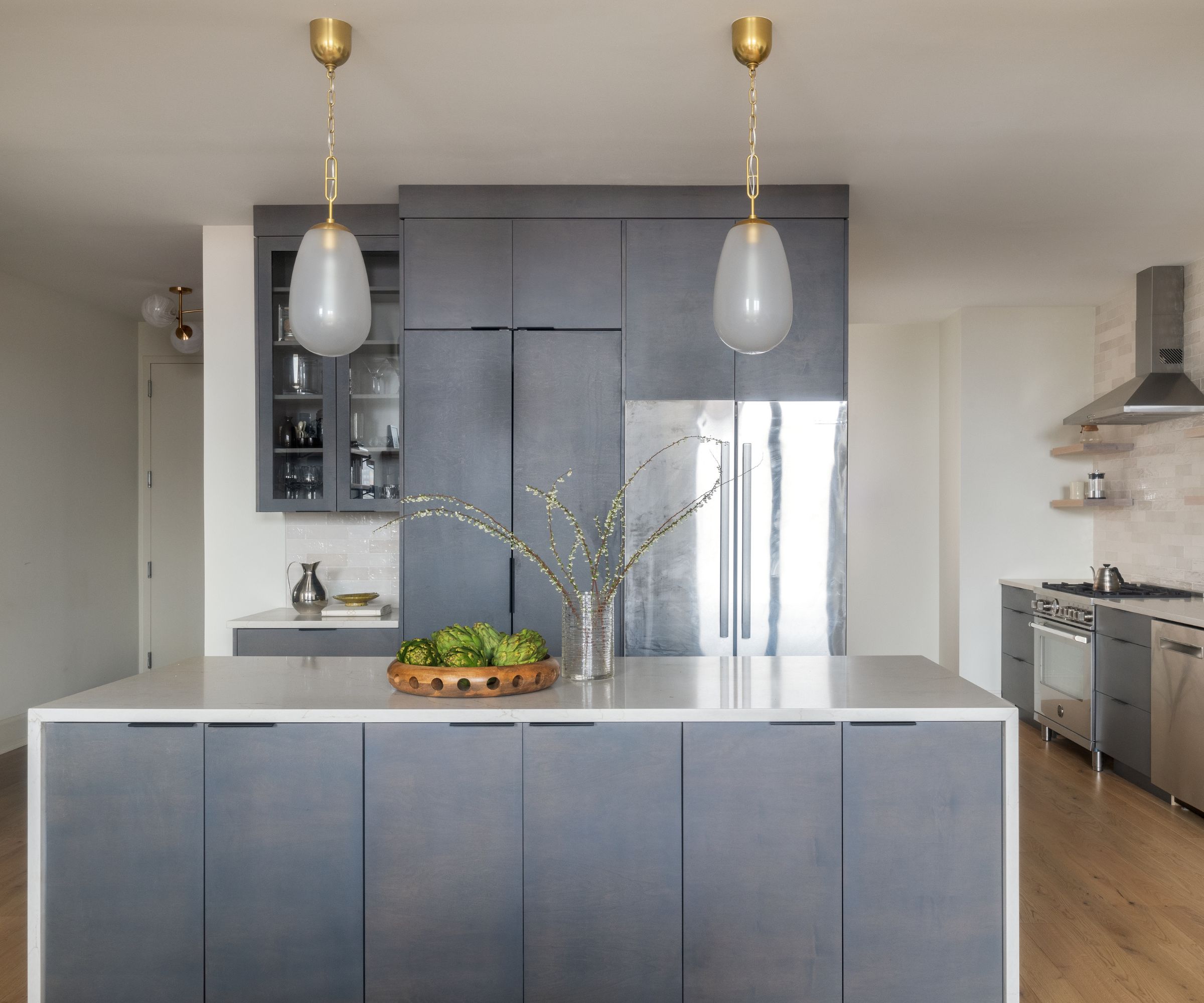 a modern kitchen with white walls, textured blue cabinets, and stainless steel appliances