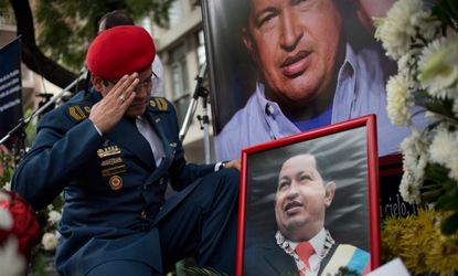 A Venezuelan army officer salutes a photo of the President Hugo Chavez at a makeshift memorial outside the Venezuelan Embassy in Buenos Aires, Argentina.