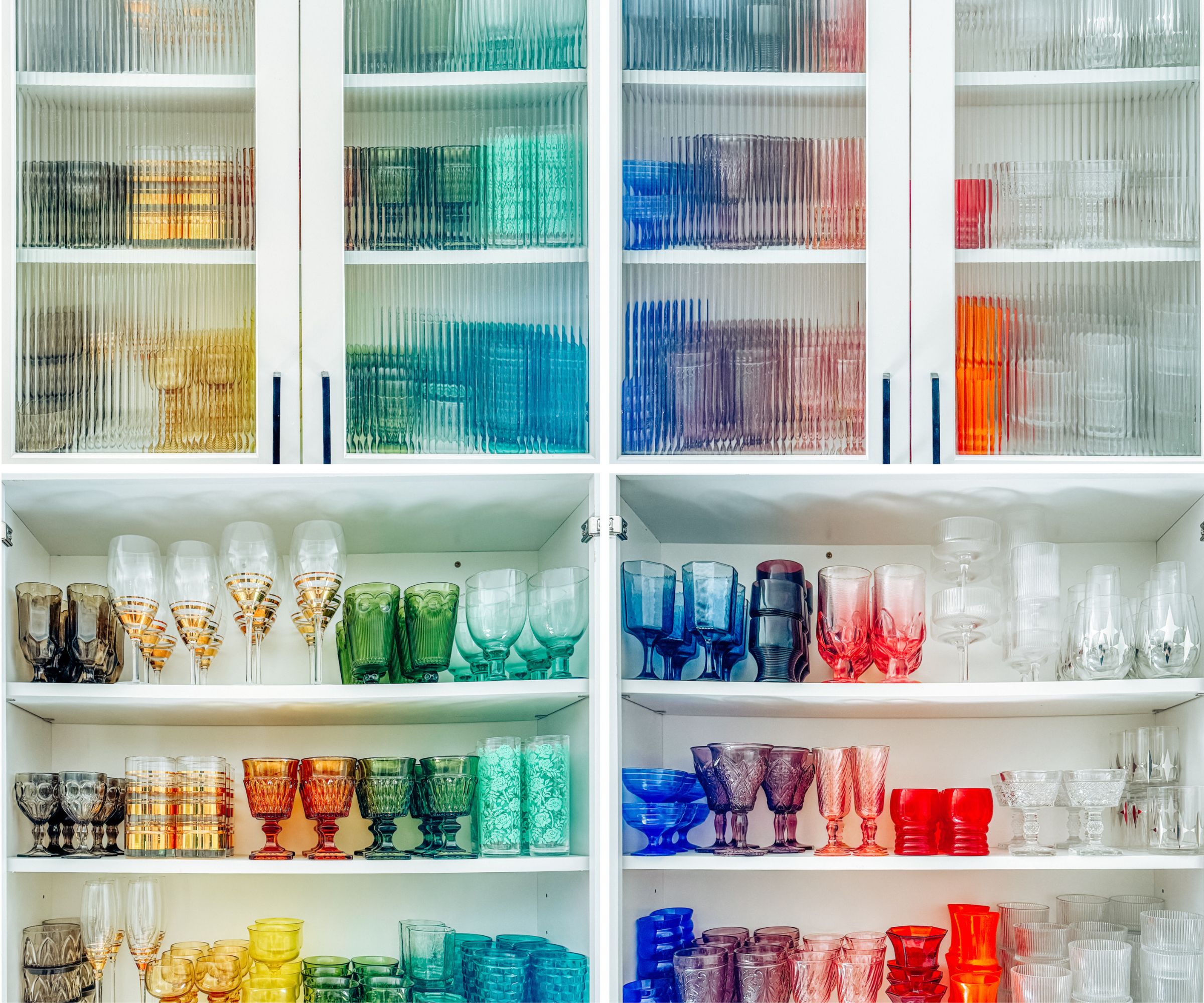 Colored glassware lined up on shelves and in cabinet