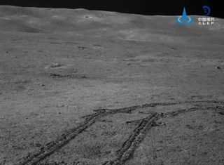 Rover tracks in the lunar regolith and the distant rim of Von Kármán crater, imaged by Yutu 2.