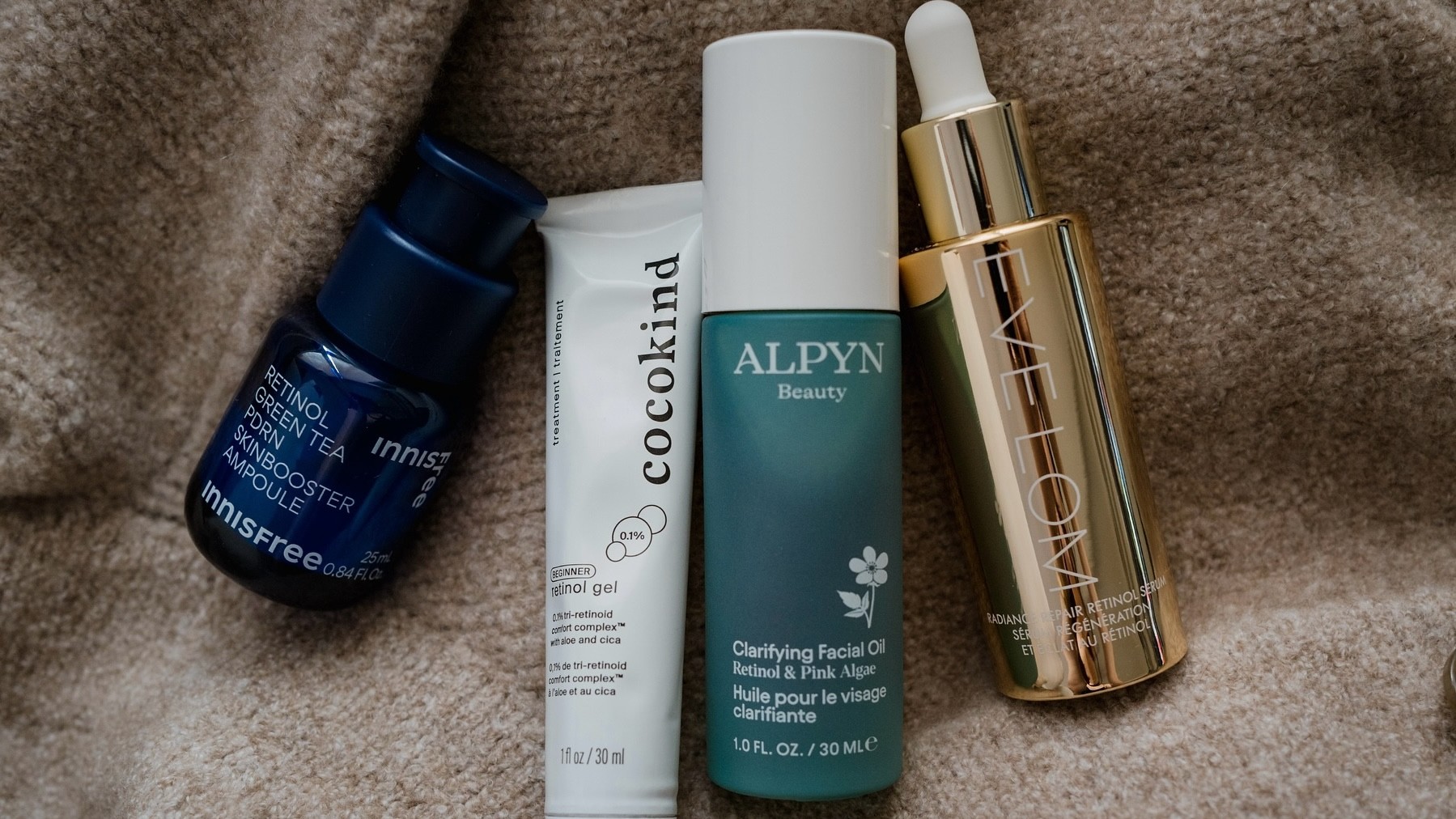 Photo of skincare products resting on a cardigan