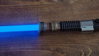 Closeup look at the Obi-Wan Kenobi Force FX Elite Lightsaber with the blade illuminated.