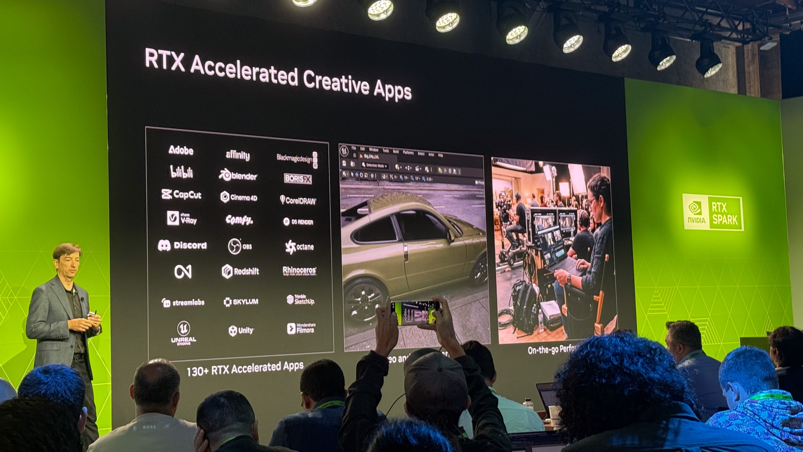 A man presenting on stage, with a slide reading 'RTX Accelerated Creative Apps'. It shows the huge range of RTX-accelerated creative apps there are, including Adobe, Affinity, Blender and Unreal.
