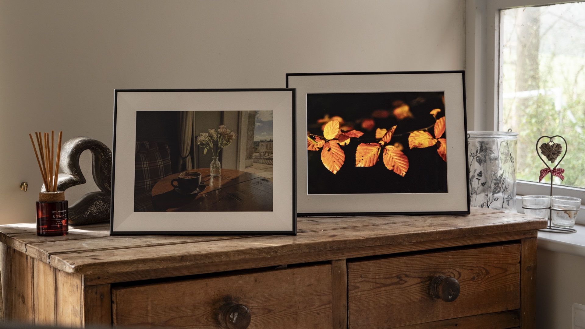 The Aura Ink 'E Ink' digital photo frame on a sideboard, alongside the Aura Walden frame