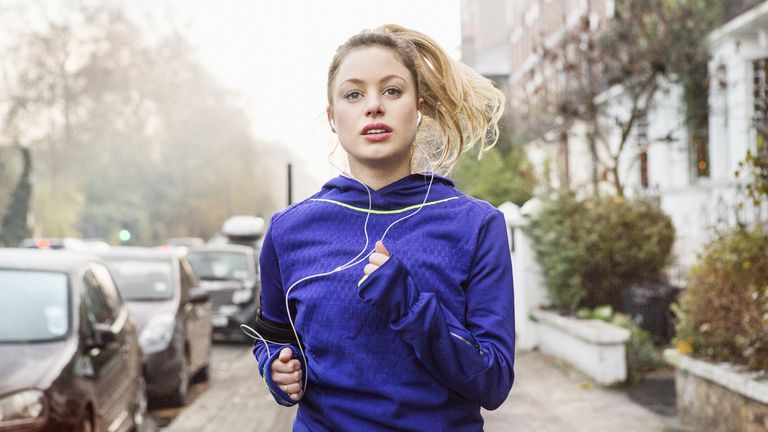 Woman outside running with headphones