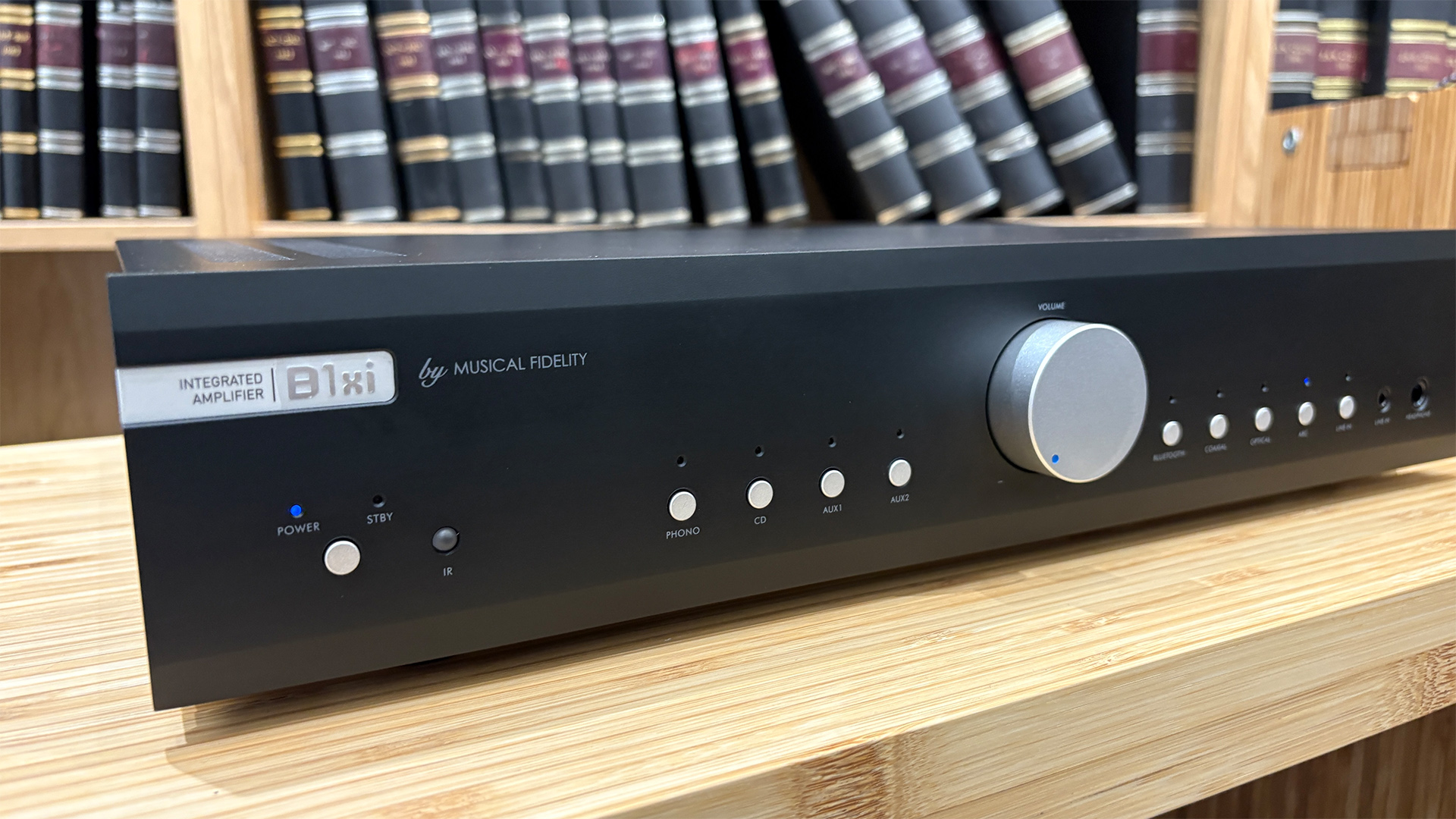 Musical Fidelity B1xi integrated amplifier on wooden hi-fi rack in front of bookcase