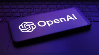 A smart phone lies screen up on an integrated laptop keyboard. The phone screen displays the OpenAI logo in white. Moody purple lighting colours the scene.