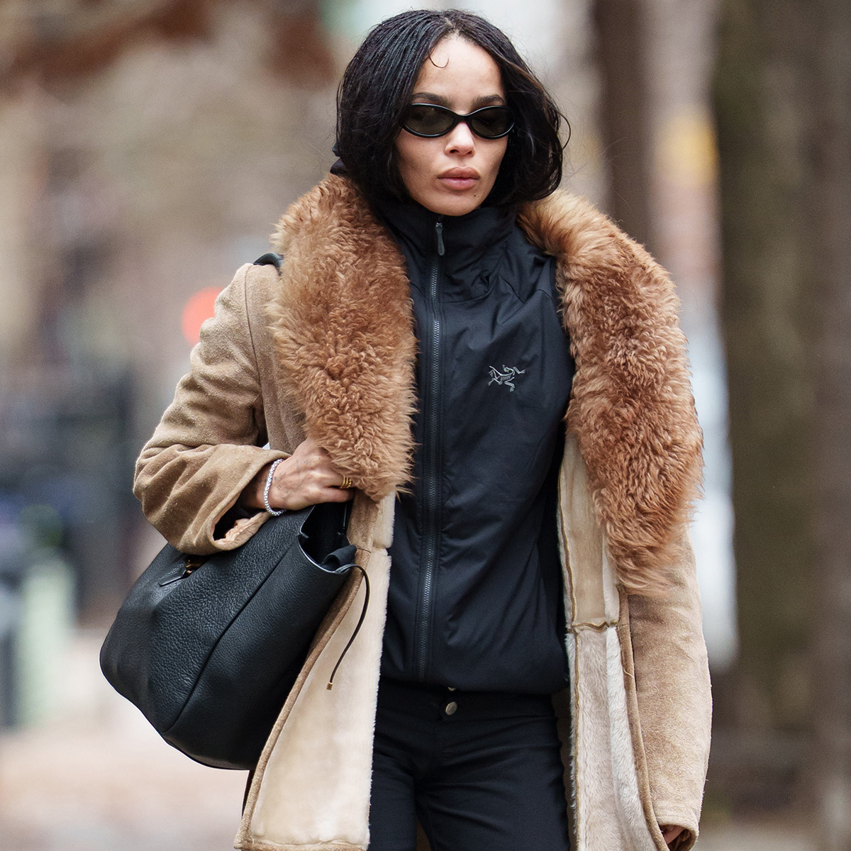 Zoe kravitz wears a fur-trimmed jacket with a black windbreaker.