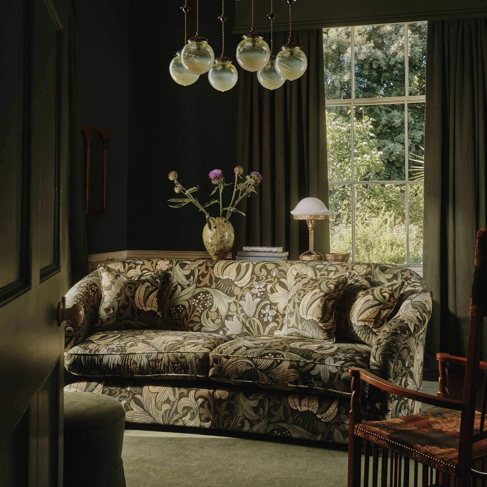 green floral sofa in a green living room