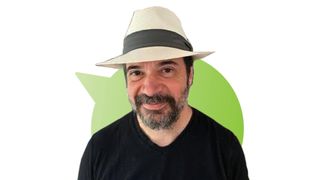 Richard Garfield wearing a hat and smiling, against a green speech bubble