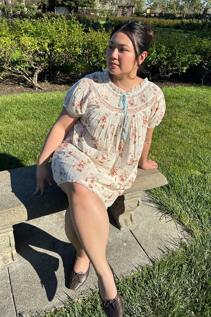 a woman wearing a babydoll dress with brown flats