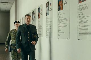 Brad Pitt, as Maj. Roy McBride, walks past a display of astronaut portraits, including one of his father and others of real-life NASA explorers, in director James Gray's "Ad Astra.