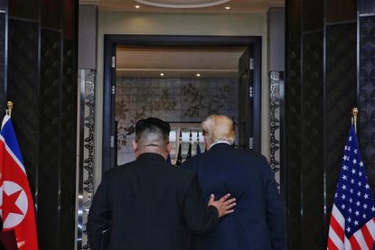 Kim places his hand on Trump's back