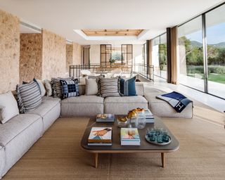 An open plan living area with grey sofa and blue cushions
