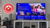 A photo of the 65-inch Sony Bravia 8 II in a living room. On the screen is a promo image for Sky's Premier League coverage and in the corner of the photo is a red logo that says 'Adventures In AV'
