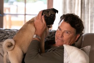 Ted McGinley as Derek, lying on a couch and holding a pug, in 'Shrinking'