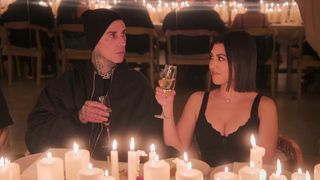 Travis Barker and Kourtney Kardashian Barker toasting glasses in The Kardashians season 3