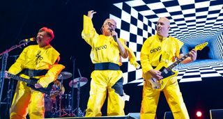 Devo perform in their yellow jumpsuits.