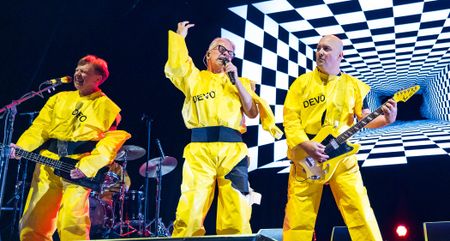 Devo perform in their yellow jumpsuits.