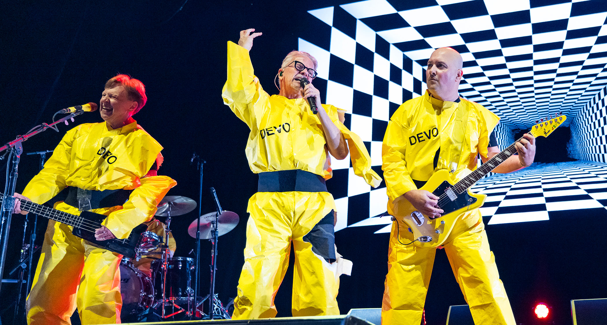 Devo perform in their yellow jumpsuits.