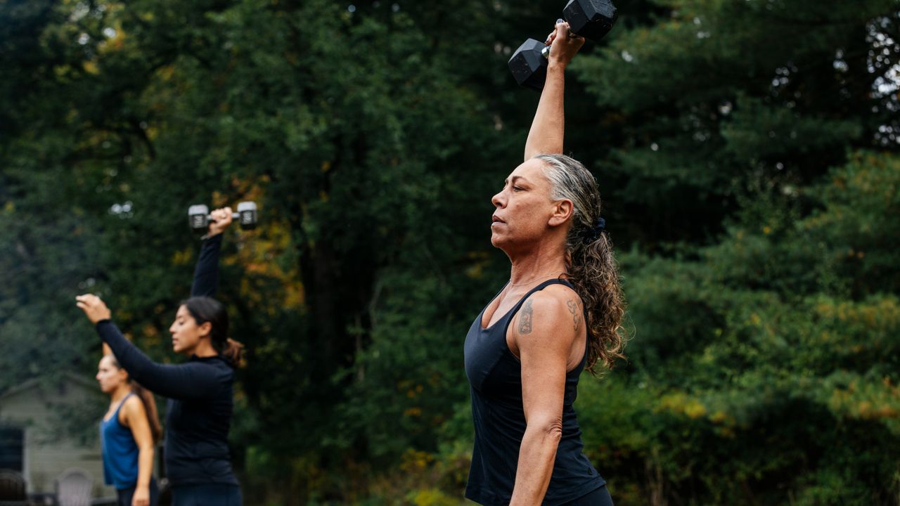 A woman lifting a dumbbell overhead