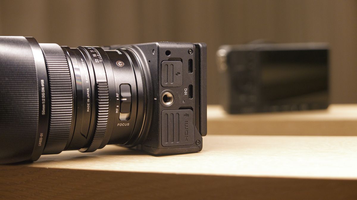 Sigma FP2 mirrorless camera with 50mm f/2 contemporary lenses attached, on a shelf, lit from above. Close up of its connection ports
