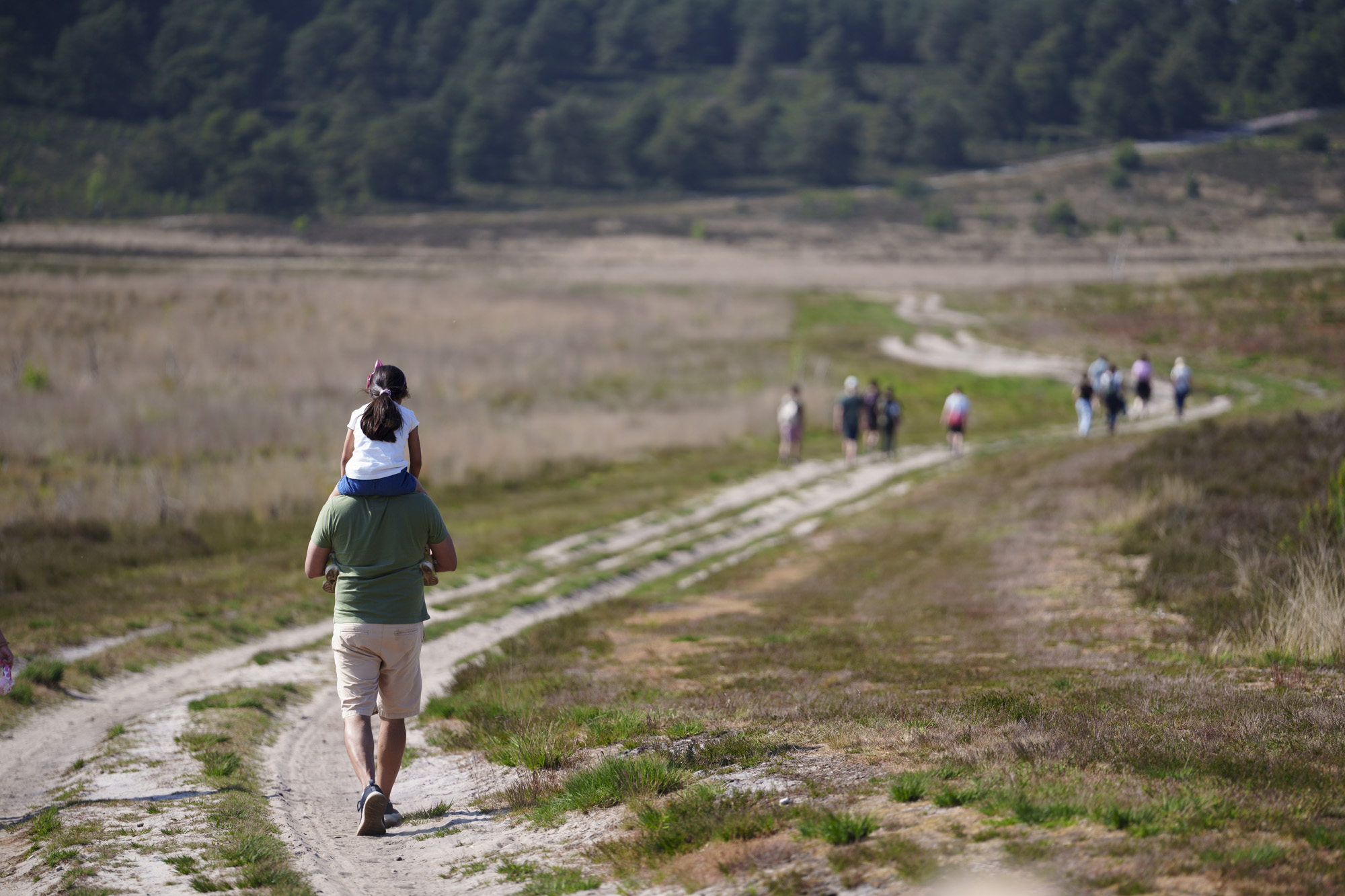 Groups of people walking in barren landscape, taken with the Sony FE 50-150mm F2 GM lens