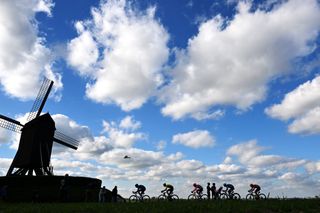 WAREGEM BELGIUM MARCH 27 LR Silhouette of Stefan Kung of Switzerland and Team Groupama FDJ Matteo Jorgenson of The United States and Team Visma Lease a Bike Alberto Bettiol of Italy and Team EF Education EasyPost Dries De Bondt of Belgium and Decathlon AG2R La Mondiale Team and Jonas Abrahamsen of Norway and Team UnoX Mobility competing in the breakaway passing close to a Windmill in the Wannegem cobblestones sector during the 78th Dwars Door Vlaanderen 2024 Mens Elite a 1886km one day race from Roeselare to Waregem UCIWT on March 27 2024 in Waregem Belgium Photo by Tim de WaeleGetty Images