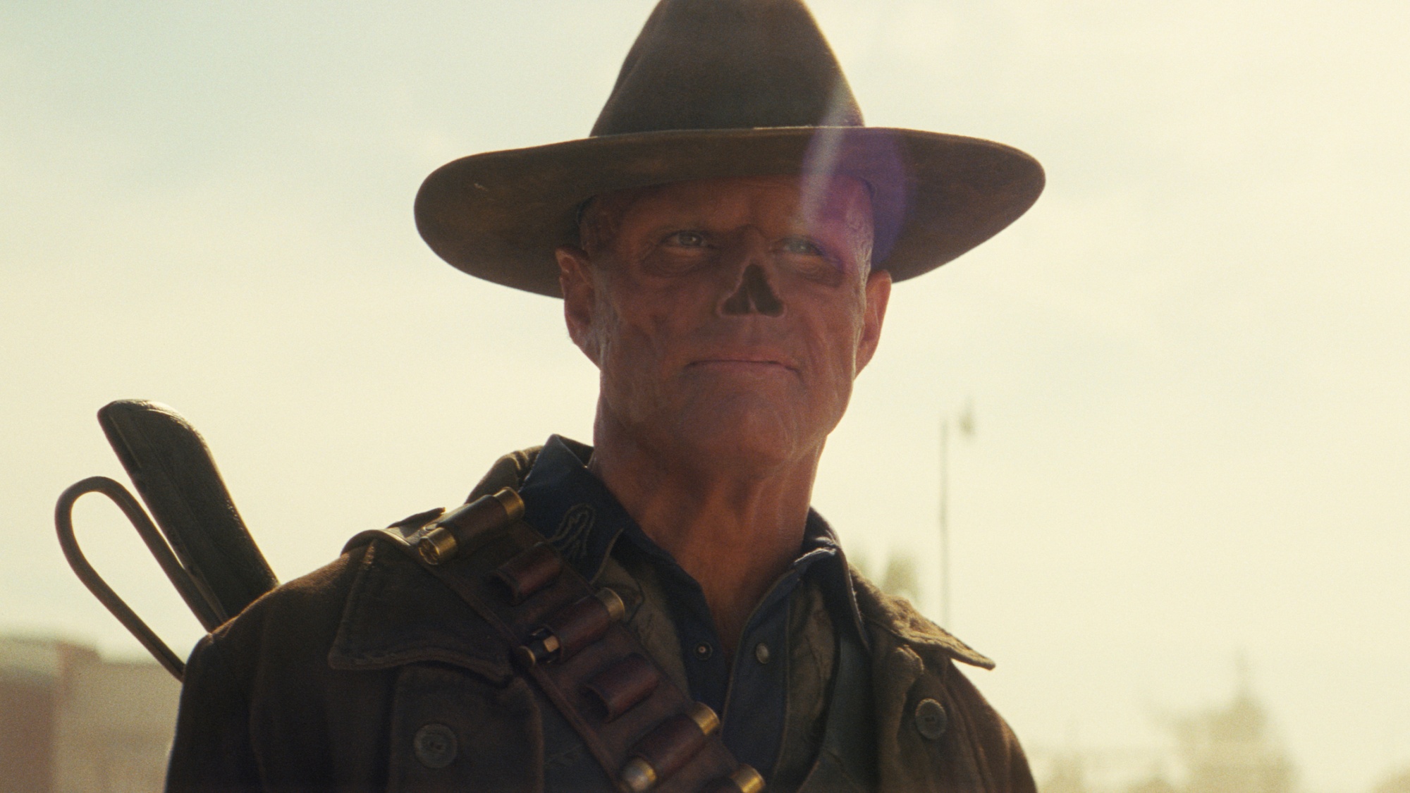 Walton Goggins as The Ghoul with a slight smile while standing outside in Fallout Season 2.