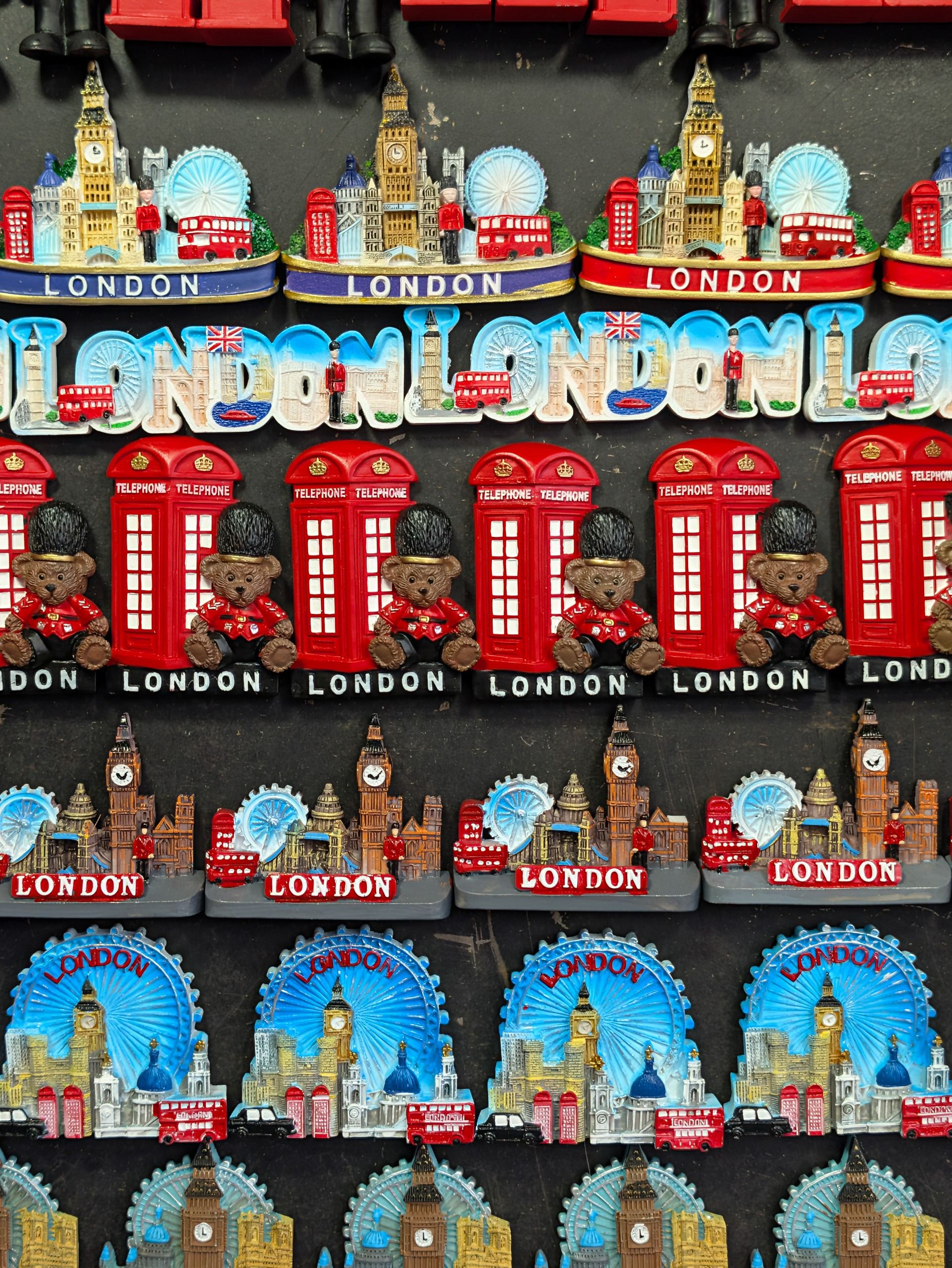 Display of colorful London souvenir magnets featuring Big Ben, red buses, telephone boxes and the London Eye.